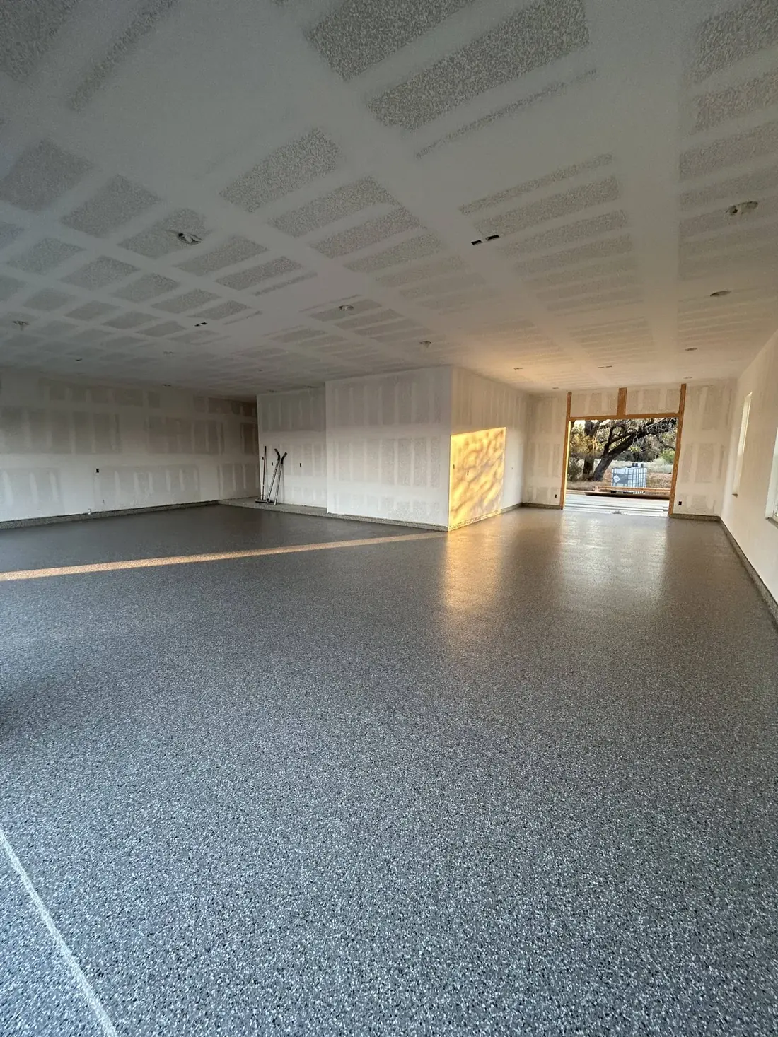 Open interior living space finished with a grey flake epoxy floor