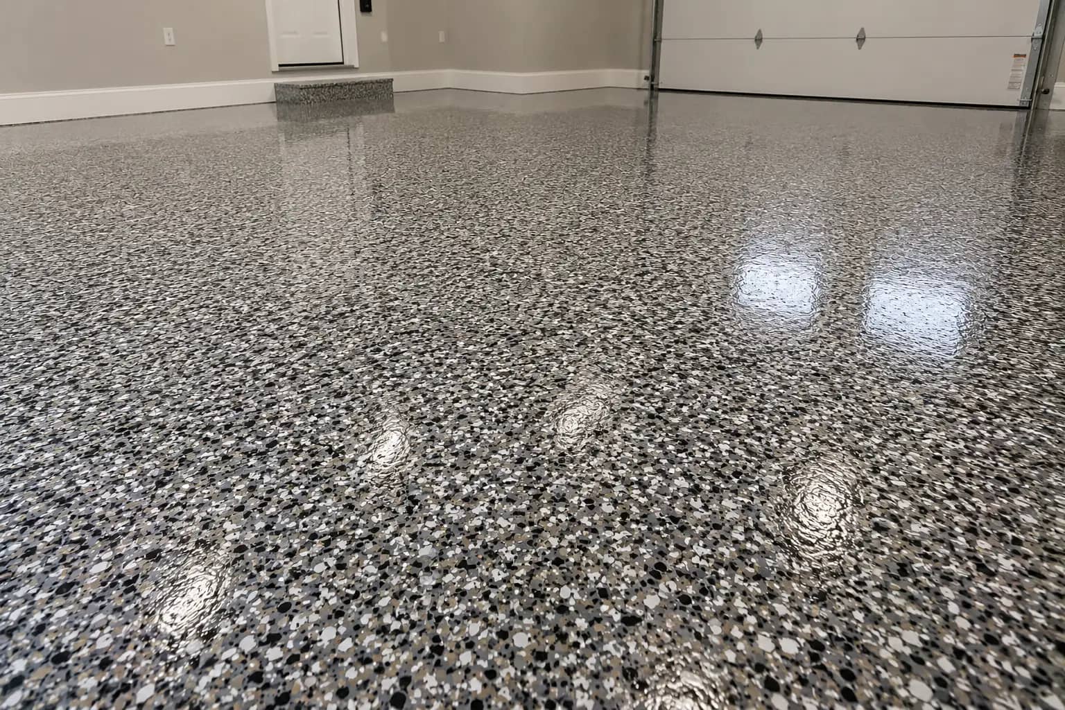 Home garage finished with a grey and black flake epoxy floor in a high-gloss finish