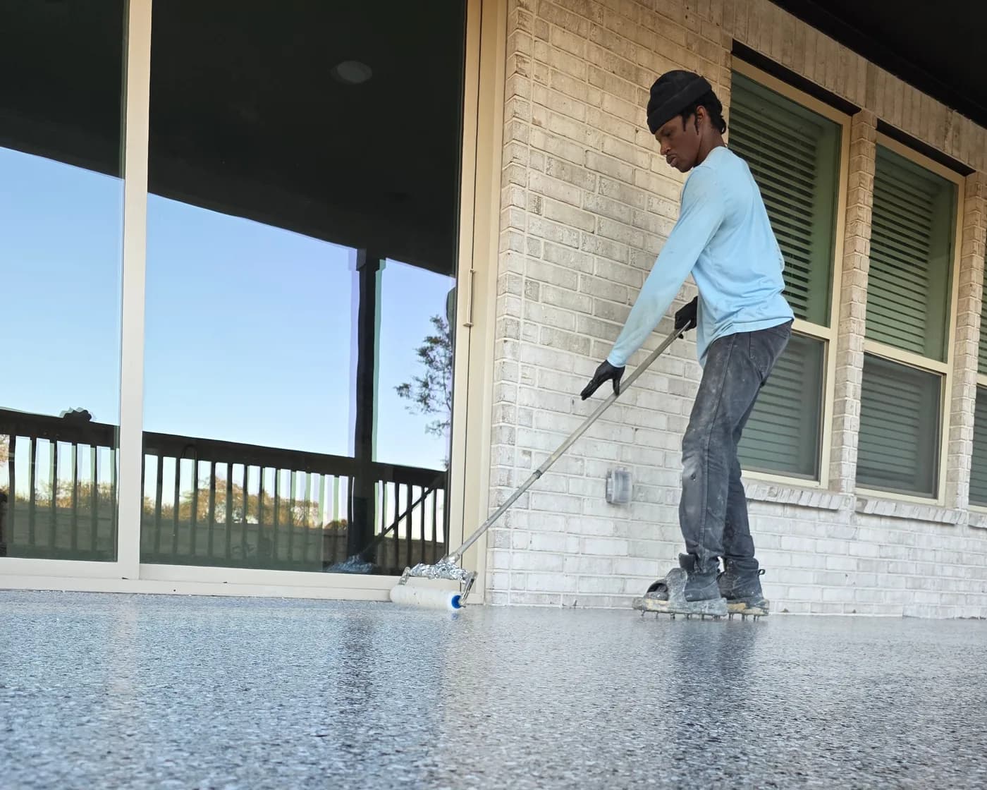 Blupoxy installer rolling a topcoat over a finished flake porch