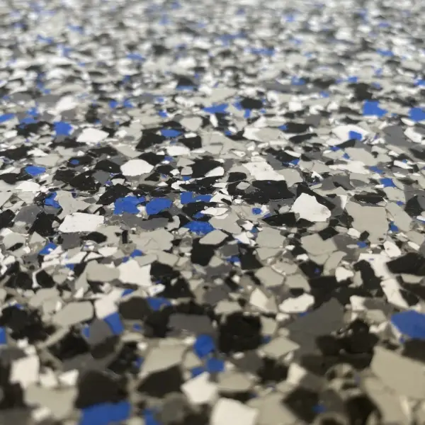 Close-up of speckled floor showing a mix of blue, gray, and black fragments creating a textured, granular appearance. No landmarks or buildings visible.