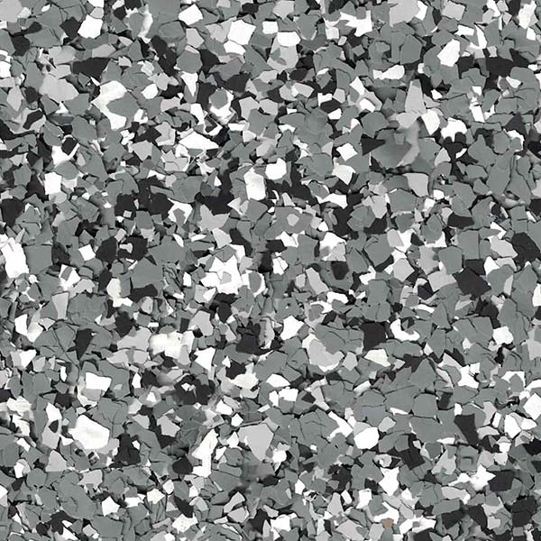 Close-up of a speckled gray and white surface, resembling a terrazzo or stone texture, with irregularly shaped chips creating a mosaic-like pattern.