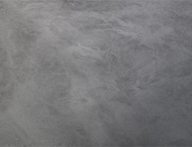 The image shows a smooth, gray surface with subtle texture and shading variations resembling concrete or stone. No landmarks or buildings visible.