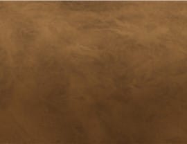 The image depicts a textured brown surface resembling a weathered wall or leather material, lacking landmarks or recognizable features.