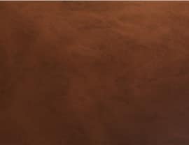 The image shows a plain, textured brown surface, resembling leather or fabric, without any recognizable landmarks or people.