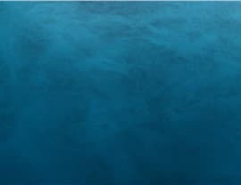 This is an abstract image featuring a textured, deep blue background with subtle variations in tone, creating a calming and serene effect.