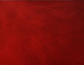 A textured deep red surface fills the entire image, creating a rich, abstract background without any identifiable objects or landmarks.
